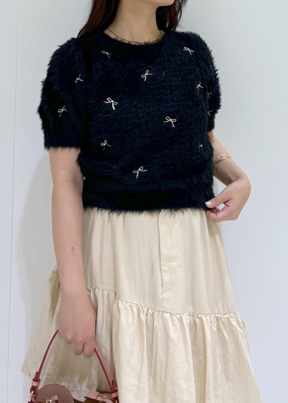 ベージュ系のドレスシューズ、ベージュ系のスカート、ブラック系のニット/セーターを着用したレディースの夏コーディネートの7枚目の写真