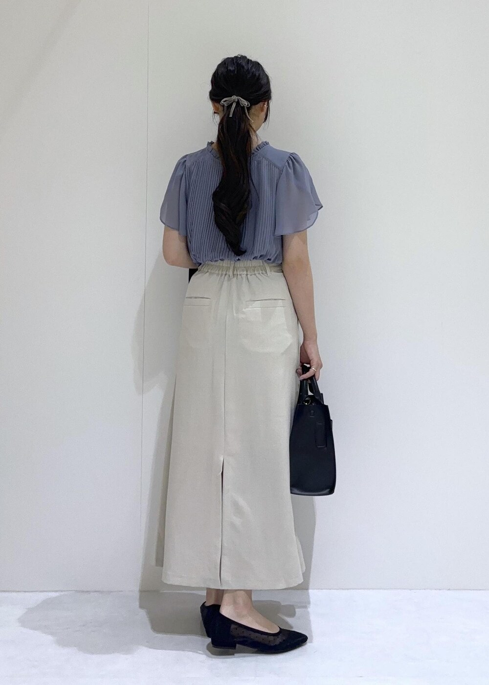 ブラック系のパンプス、ホワイト系のスカート、ブルー系のシャツ/ブラウスを着用したレディースの夏コーディネートの4枚目の写真