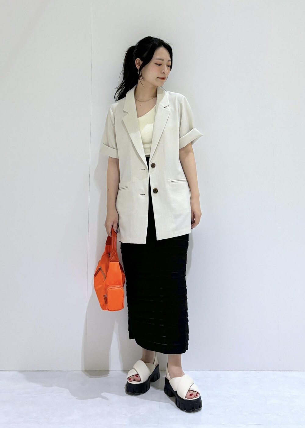 ホワイト系のサンダル、ブラック系のスカート、ホワイト系のタンクトップを着用したレディースの夏コーディネートの2枚目の写真