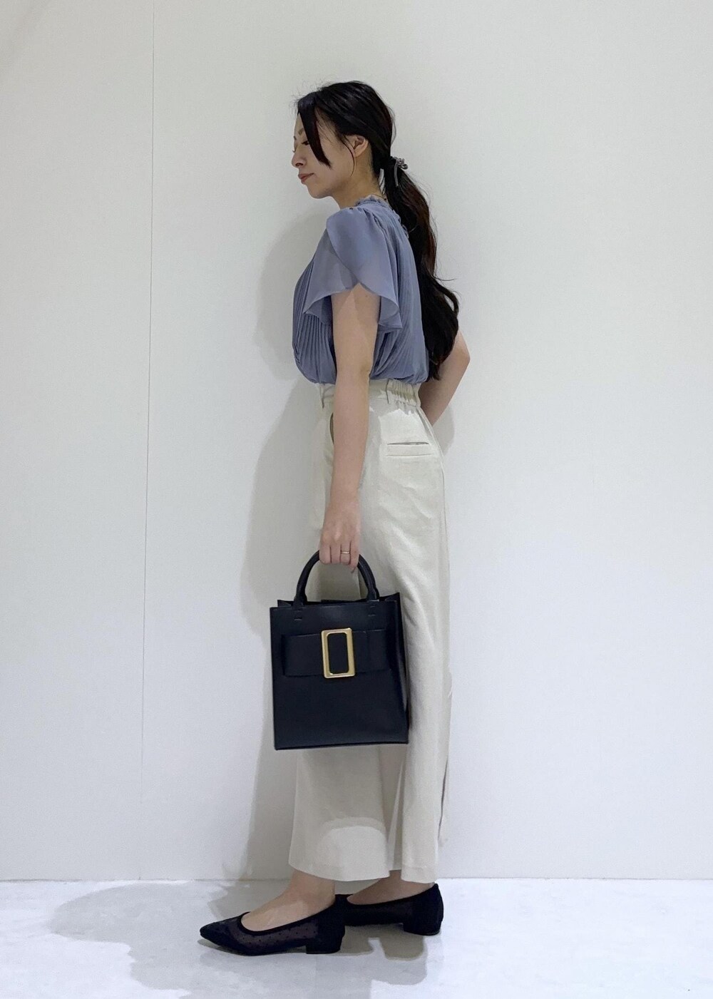 ブラック系のパンプス、ホワイト系のスカート、ブルー系のシャツ/ブラウスを着用したレディースの夏コーディネートの3枚目の写真