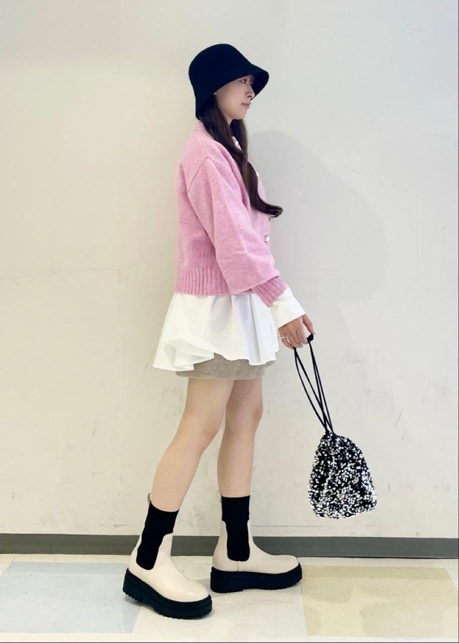 ホワイト系のブーツ、シルバー系のハンドバッグ、ピンク系のカーディガン/ボレロを着用したレディースの秋コーディネートの2枚目の写真