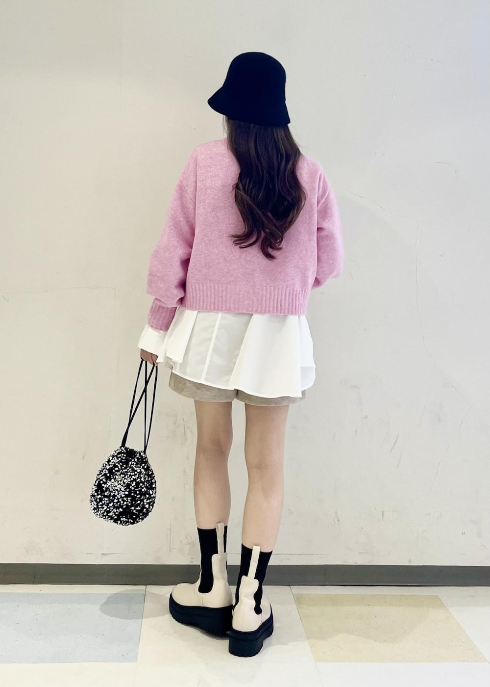 ホワイト系のブーツ、シルバー系のハンドバッグ、ピンク系のカーディガン/ボレロを着用したレディースの秋コーディネートの3枚目の写真