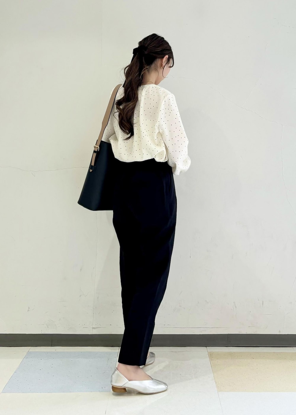 シルバー系のパンプス、ホワイト系のシャツ/ブラウス、ブラック系のスラックスを着用したレディースの春コーディネートの2枚目の写真