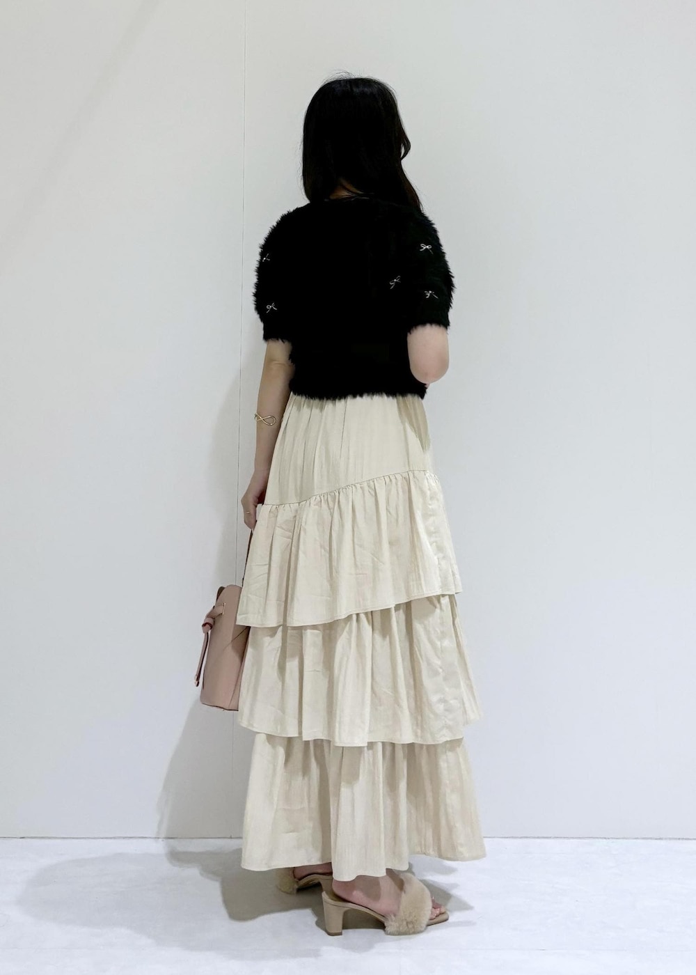 ベージュ系のドレスシューズ、ベージュ系のスカート、ブラック系のニット/セーターを着用したレディースの夏コーディネートの4枚目の写真