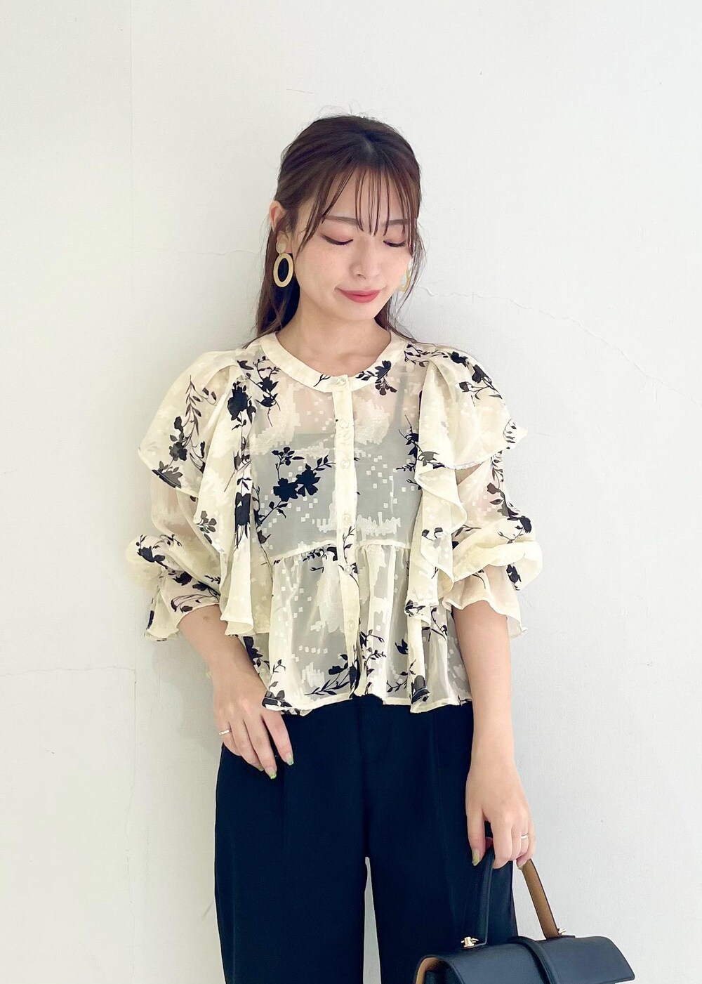 ブラック系のスラックス、ホワイト系のシャツ/ブラウス、ブラック系のハンドバッグを着用したレディースの秋コーディネートの5枚目の写真