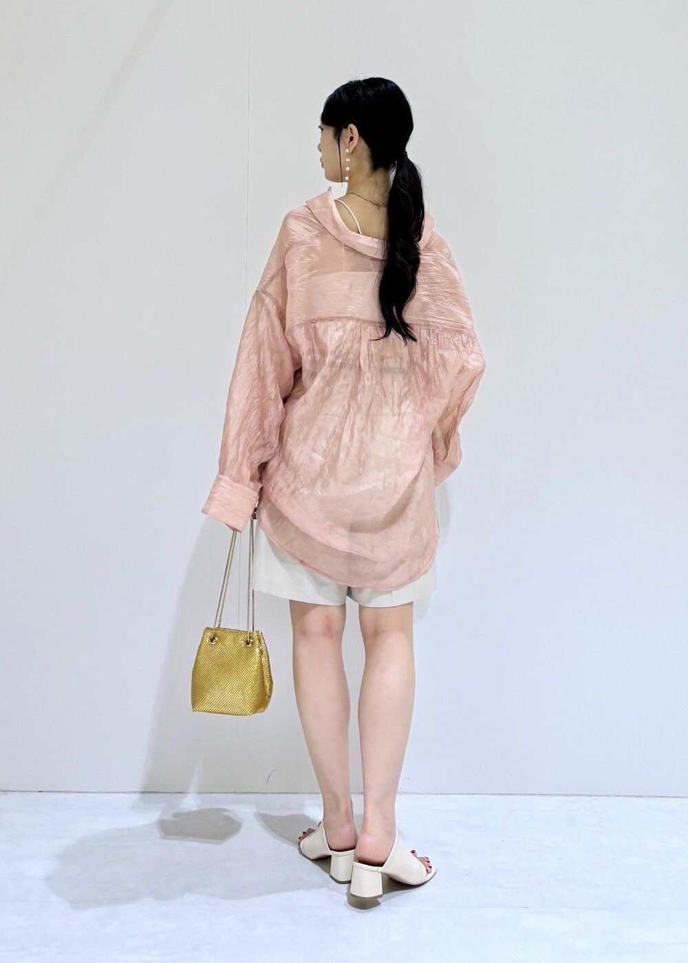 ホワイト系のキャミソール、ゴールド系のショルダーバッグ、ホワイト系のその他パンツを着用したレディースの夏コーディネートの4枚目の写真