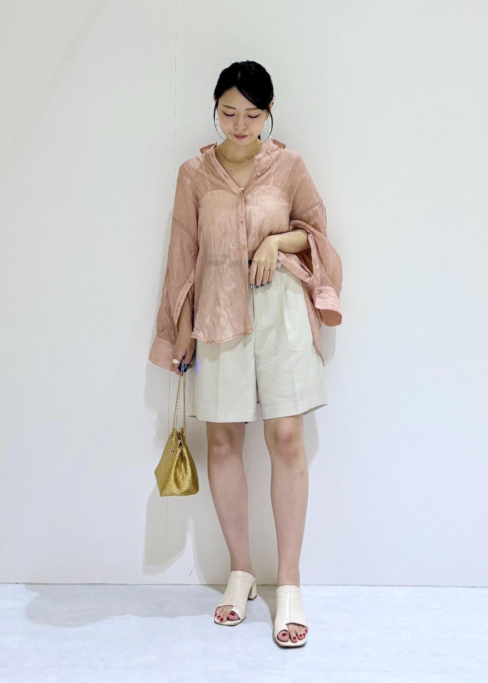 ホワイト系のキャミソール、ゴールド系のショルダーバッグ、ホワイト系のその他パンツを着用したレディースの夏コーディネートの2枚目の写真