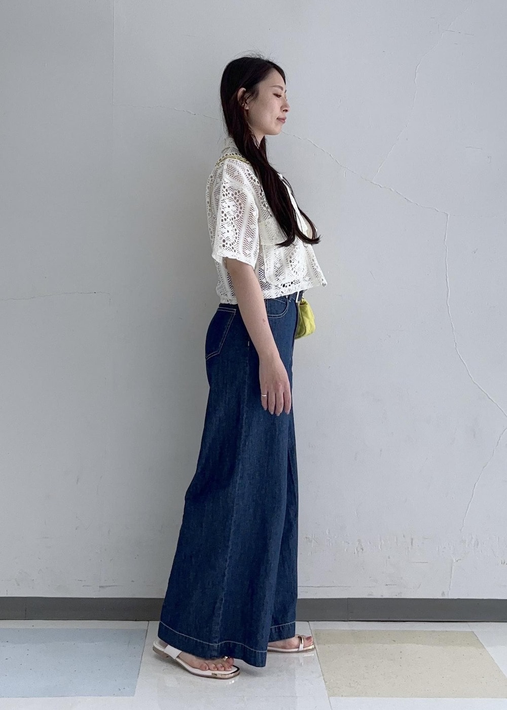 イエロー系のショルダーバッグ、ホワイト系のサンダル、ホワイト系のカーディガン/ボレロを着用したレディースの春コーディネートの2枚目の写真