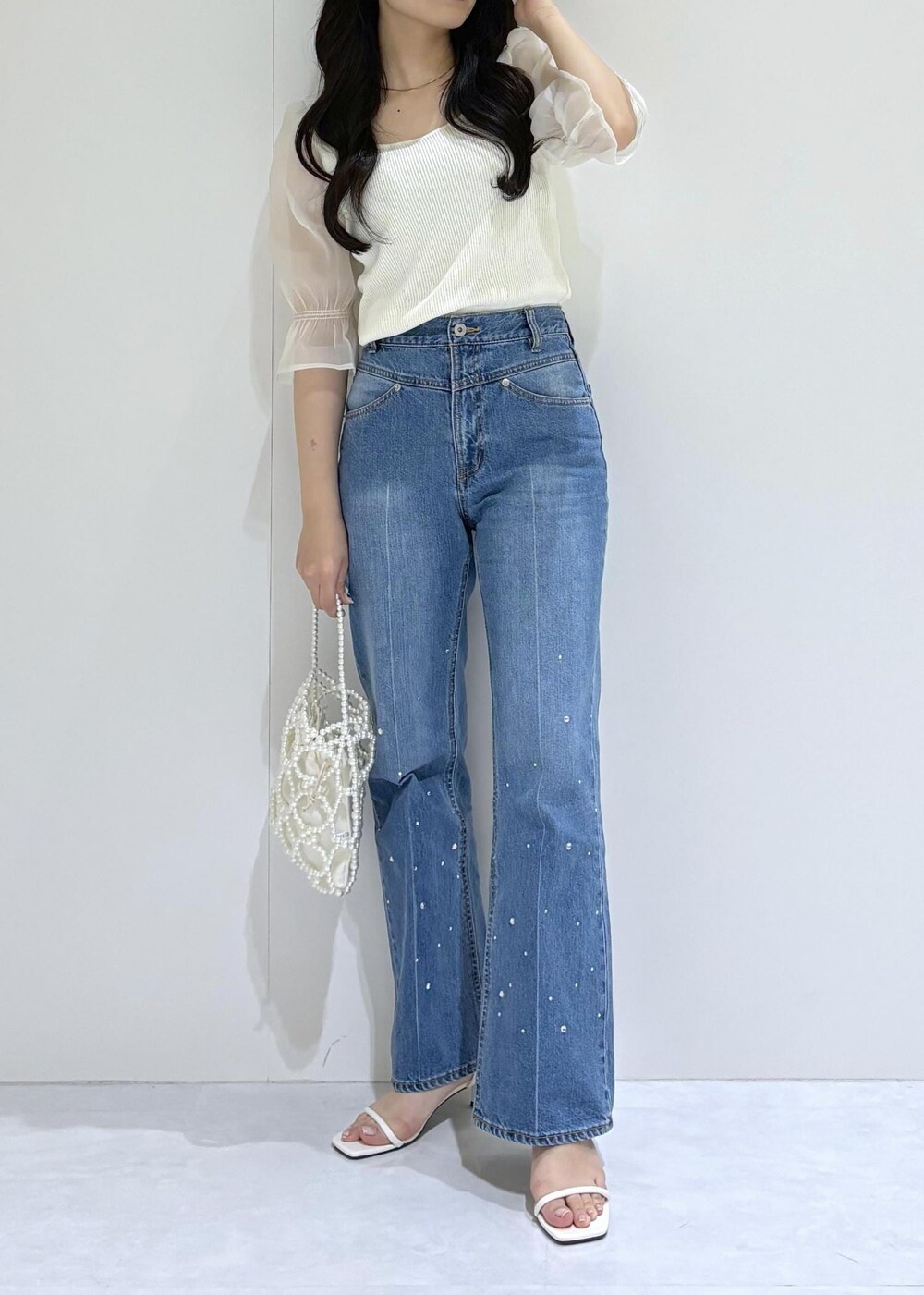 ホワイト系のサンダル、ホワイト系のTシャツ/カットソー、ホワイト系のハンドバッグを着用したレディースの夏コーディネートの4枚目の写真