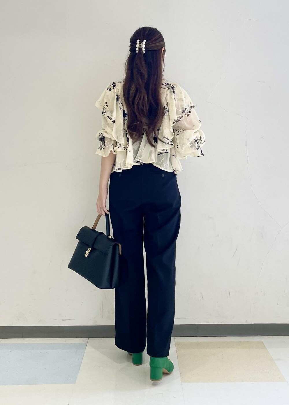 ブラック系のスラックス、ホワイト系のシャツ/ブラウス、ブラック系のハンドバッグを着用したレディースの秋コーディネートの3枚目の写真