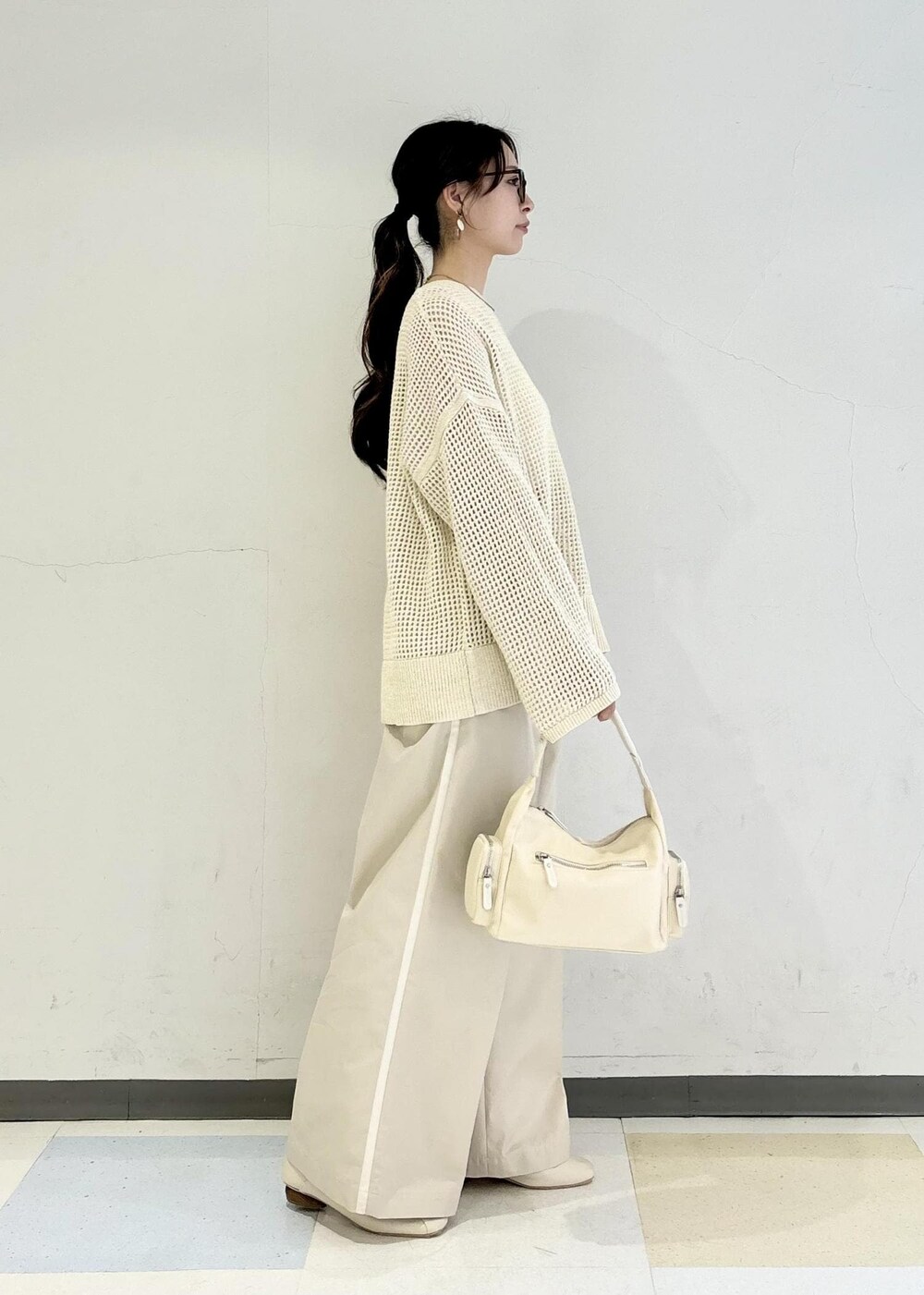 ホワイト系のパンプス、ホワイト系のキャミソール、ホワイト系のニット/セーターを着用したレディースの春コーディネートの2枚目の写真