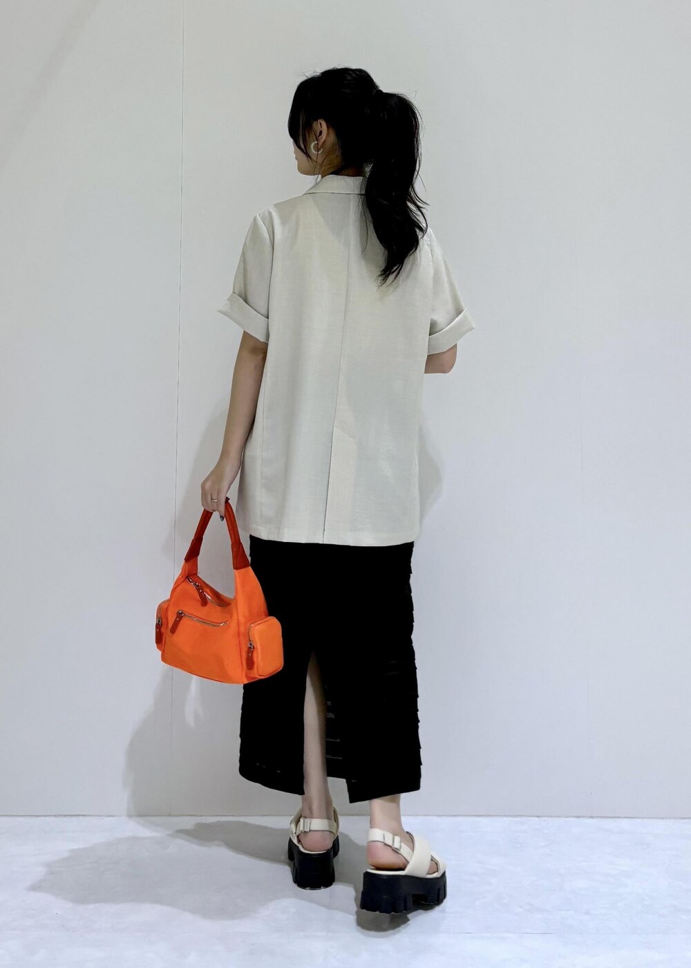 ホワイト系のサンダル、ブラック系のスカート、ホワイト系のタンクトップを着用したレディースの夏コーディネートの4枚目の写真