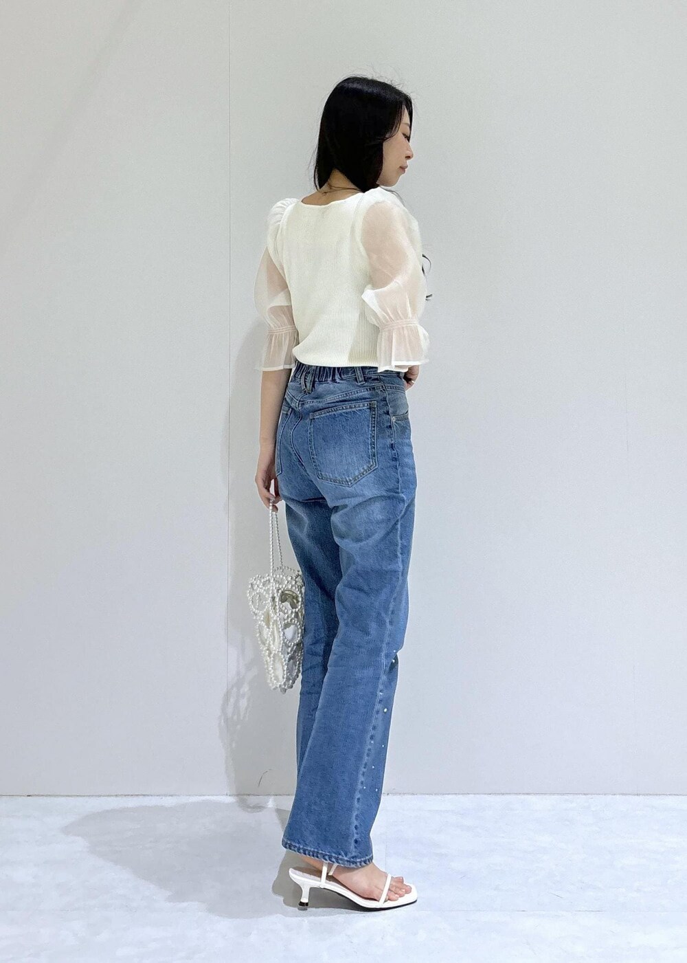 ホワイト系のサンダル、ホワイト系のTシャツ/カットソー、ホワイト系のハンドバッグを着用したレディースの夏コーディネートの3枚目の写真