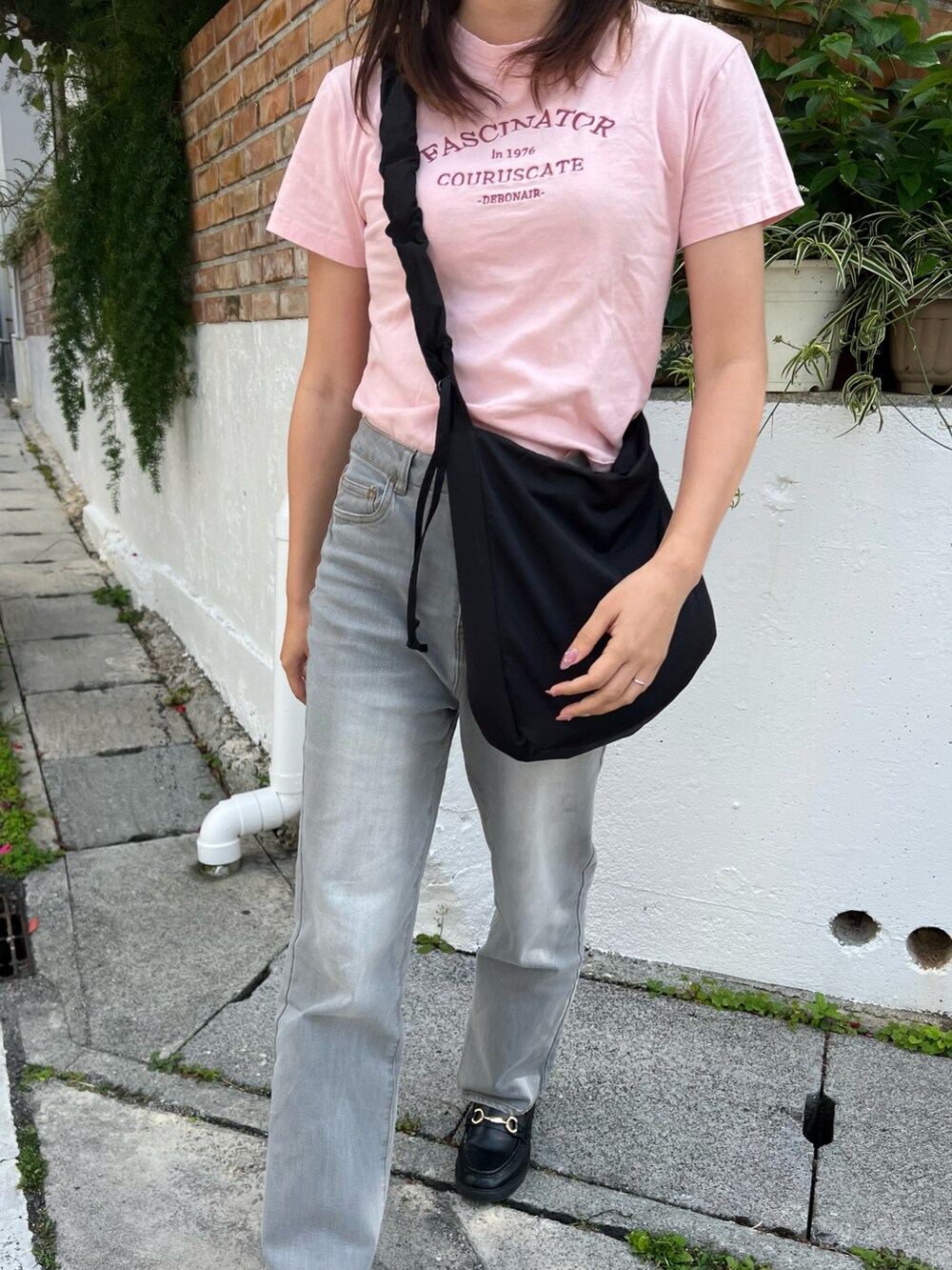 グレー系のデニムパンツ、ブラック系のバッグ、ブラック系のローファーを着用したレディースの春コーディネートの3枚目の写真