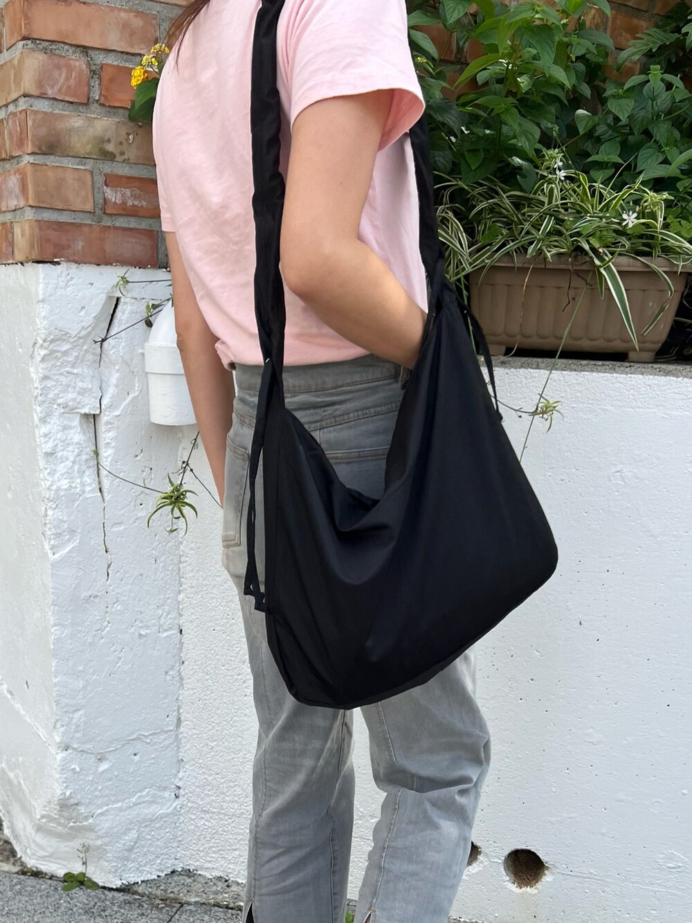 グレー系のデニムパンツ、ブラック系のバッグ、ブラック系のローファーを着用したレディースの春コーディネートの2枚目の写真