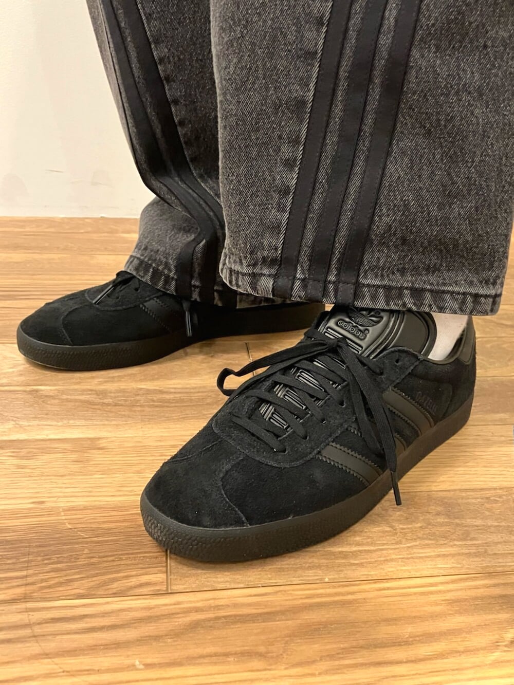 ブラック系のスニーカー、ブラック系のパーカー、ブラック系のデニムパンツを着用したメンズの冬コーディネートの4枚目の写真