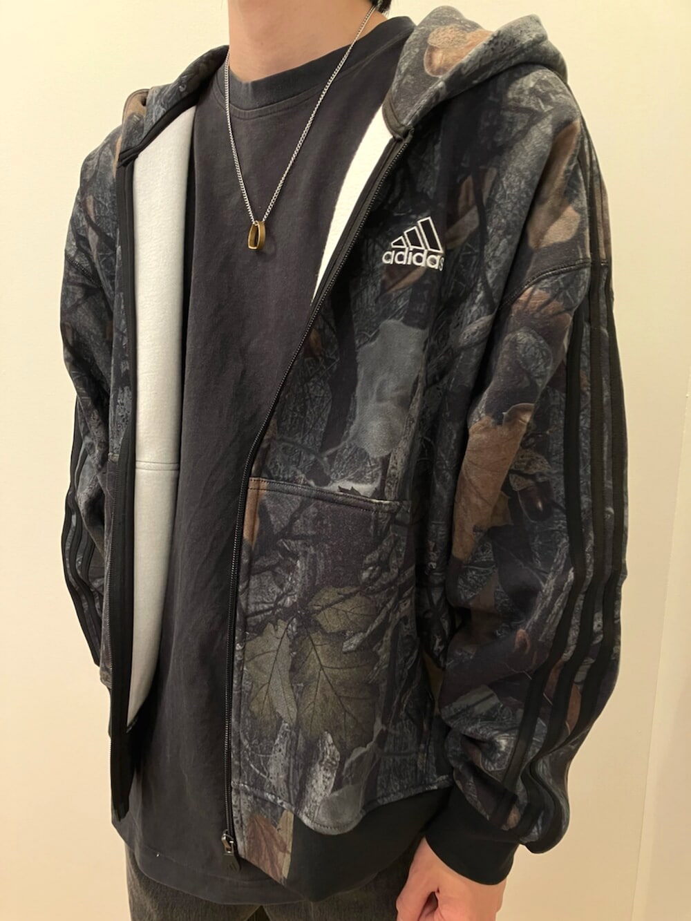 ブラック系のスニーカー、ブラック系のパーカー、ブラック系のデニムパンツを着用したメンズの冬コーディネートの2枚目の写真