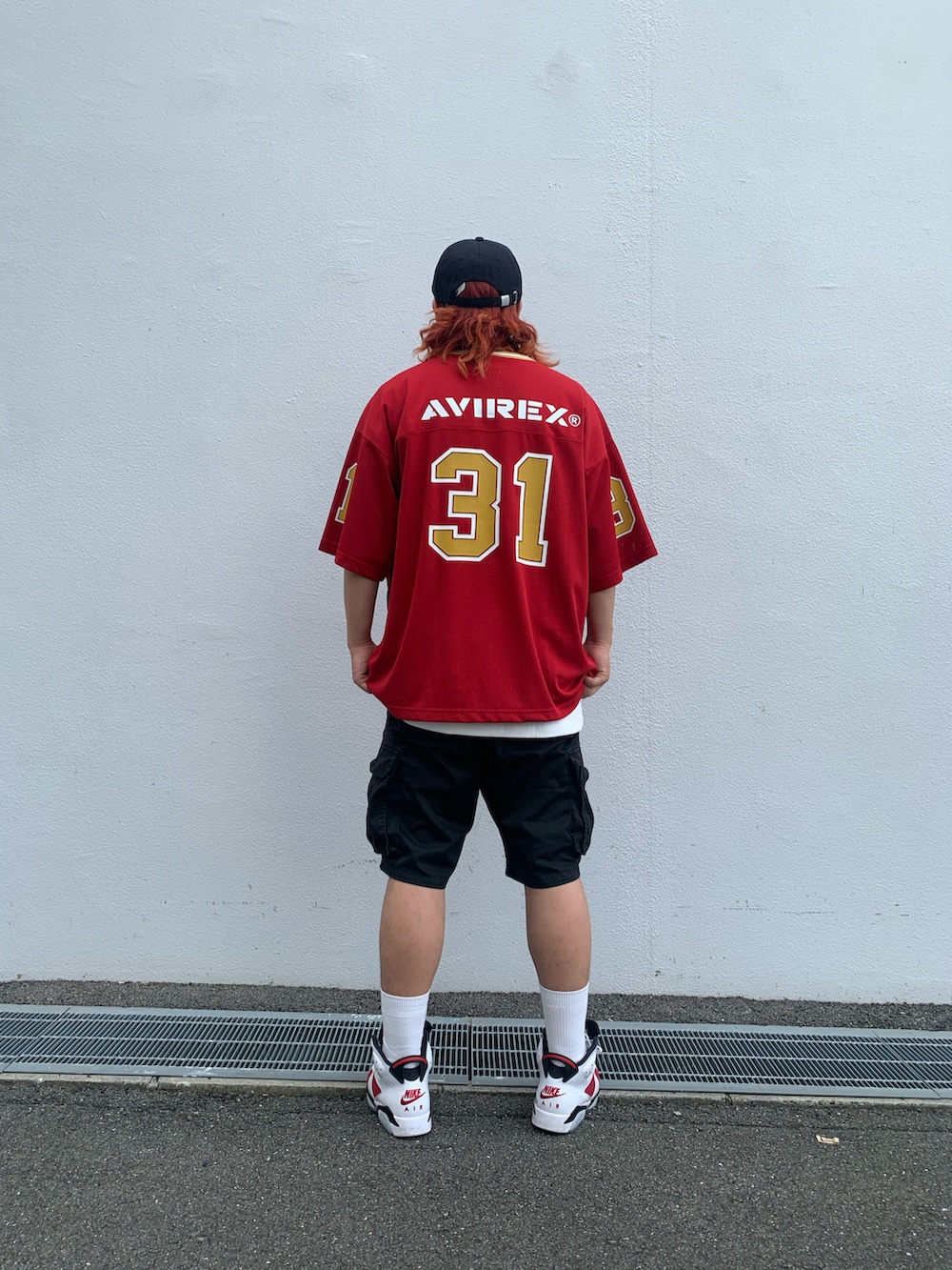 レッド系のTシャツ/カットソー、ブラック系のキャップ、シルバー系のネックレスを着用したメンズの夏コーディネートの2枚目の写真