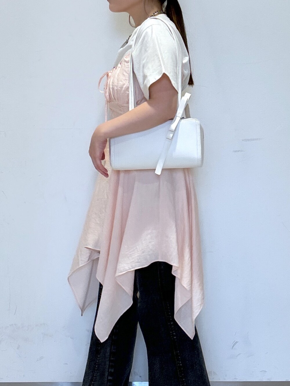 ピンク系のワンピース、ホワイト系のTシャツ/カットソー、ホワイト系のショルダーバッグを着用したレディースの春コーディネートの5枚目の写真