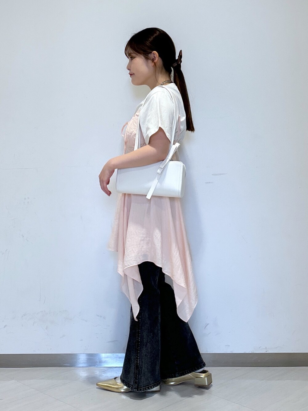 ピンク系のワンピース、ホワイト系のTシャツ/カットソー、ホワイト系のショルダーバッグを着用したレディースの春コーディネートの2枚目の写真