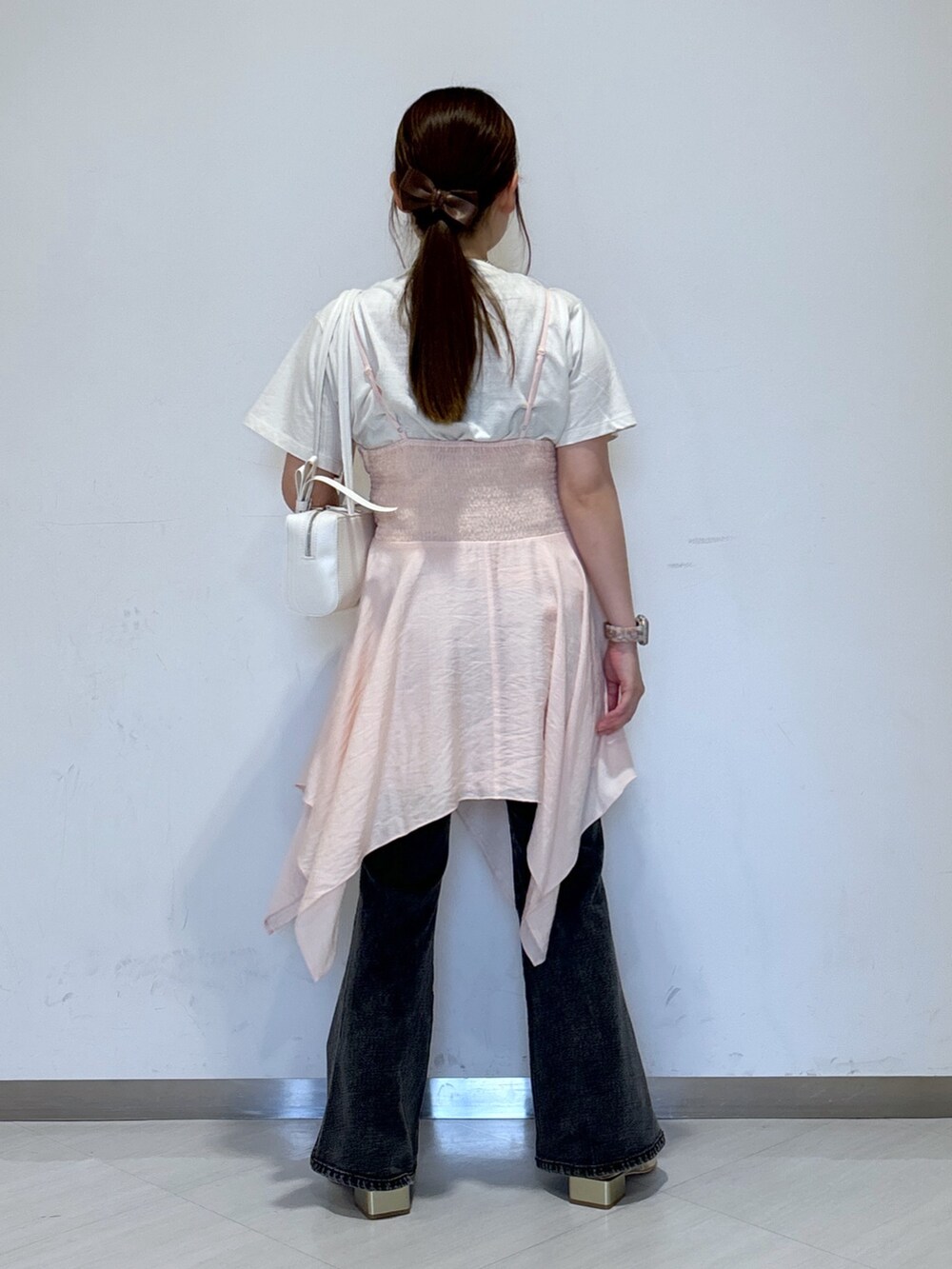 ピンク系のワンピース、ホワイト系のTシャツ/カットソー、ホワイト系のショルダーバッグを着用したレディースの春コーディネートの3枚目の写真