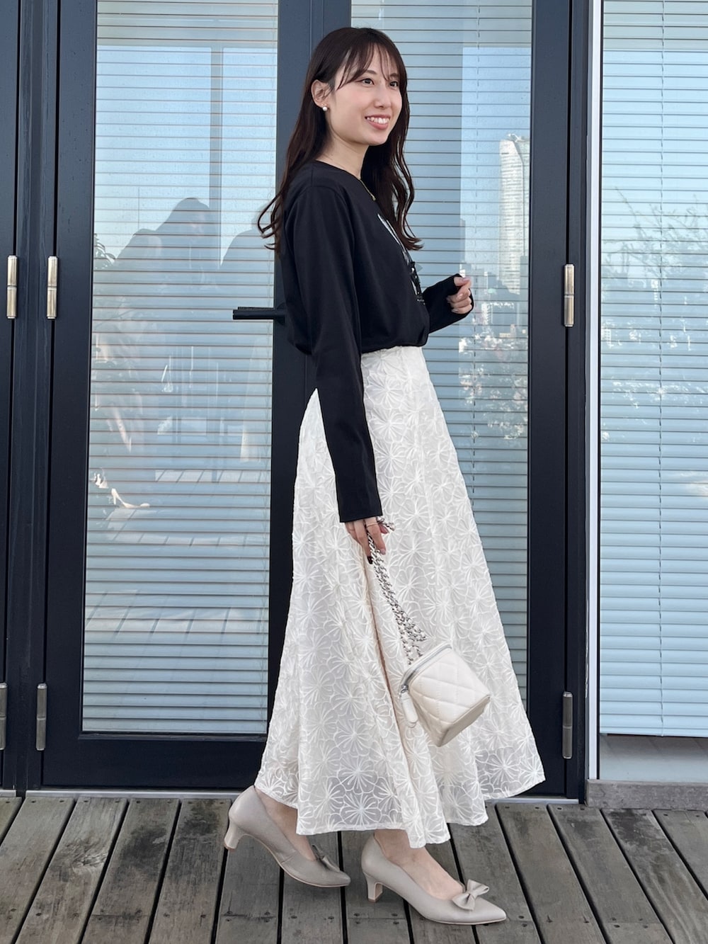 ベージュ系のスカート、ホワイト系のTシャツ/カットソーを着用したレディースの春コーディネートの2枚目の写真