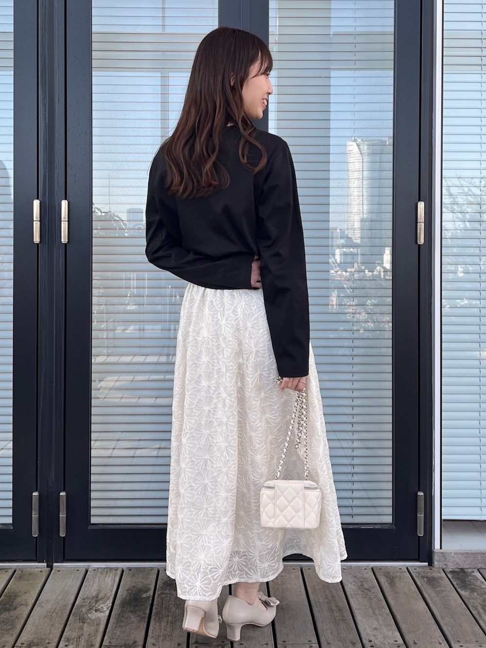 ベージュ系のスカート、ホワイト系のTシャツ/カットソーを着用したレディースの春コーディネートの4枚目の写真