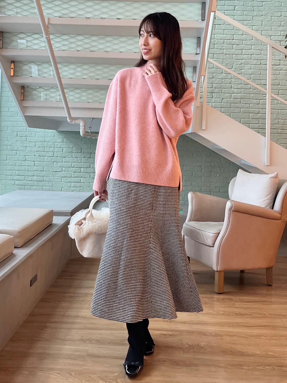 ベージュ系のその他アウター、ピンク系のニット/セーター、ブラック系のスカートを着用したレディースの秋コーディネートの3枚目の写真