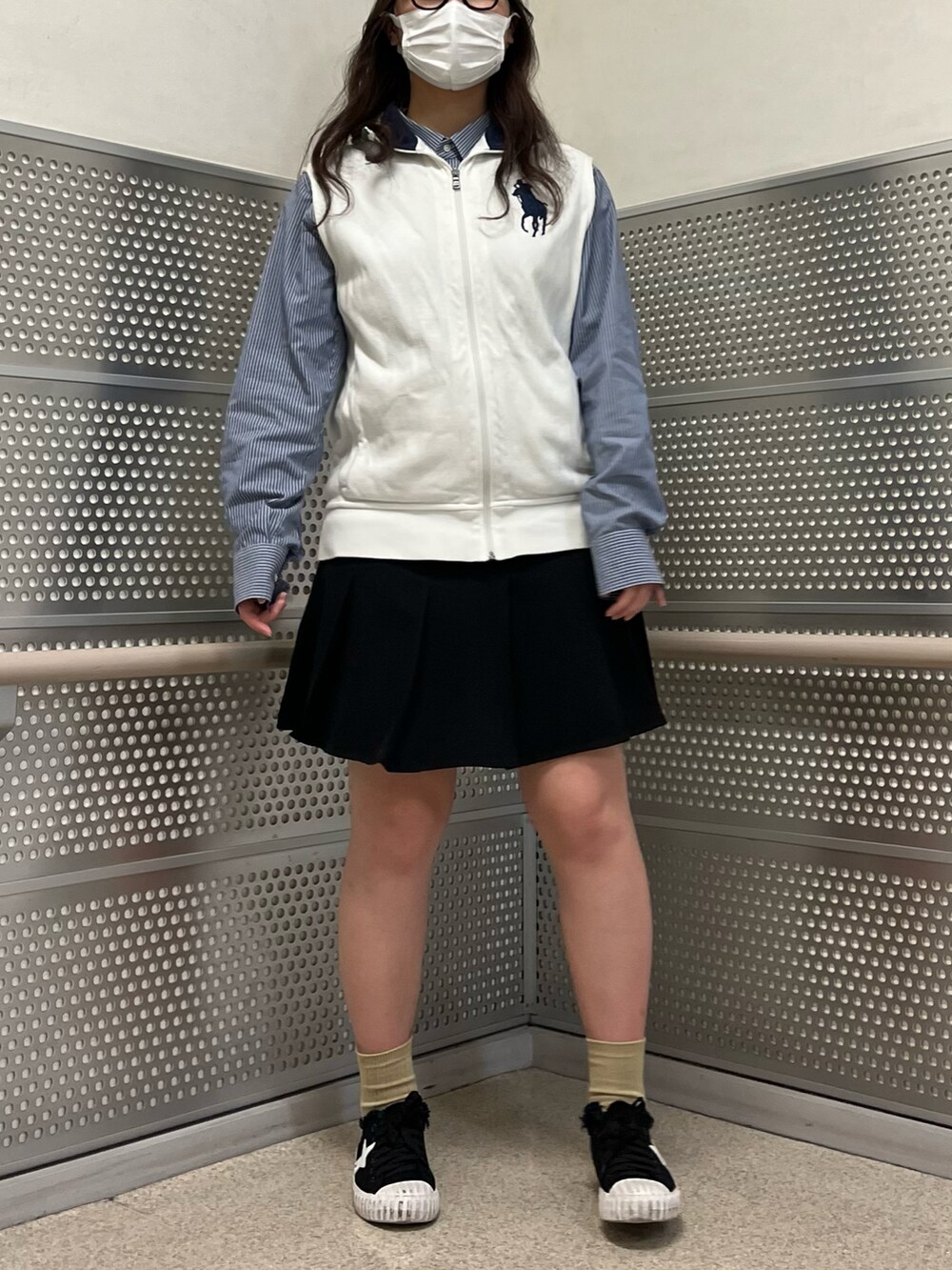 ブラック系のスカート、ホワイト系のベスト、ブルー系のシャツ/ブラウスを着用したレディースの春コーディネートの4枚目の写真