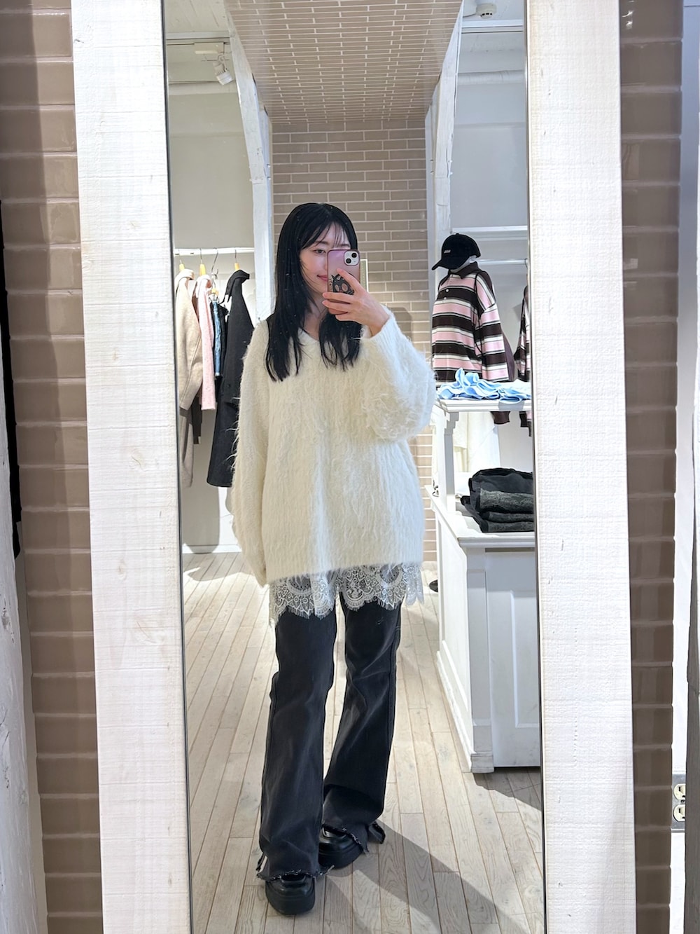 ホワイト系のニット/セーター、ブルー系のデニムパンツを着用したレディースの秋コーディネートの4枚目の写真