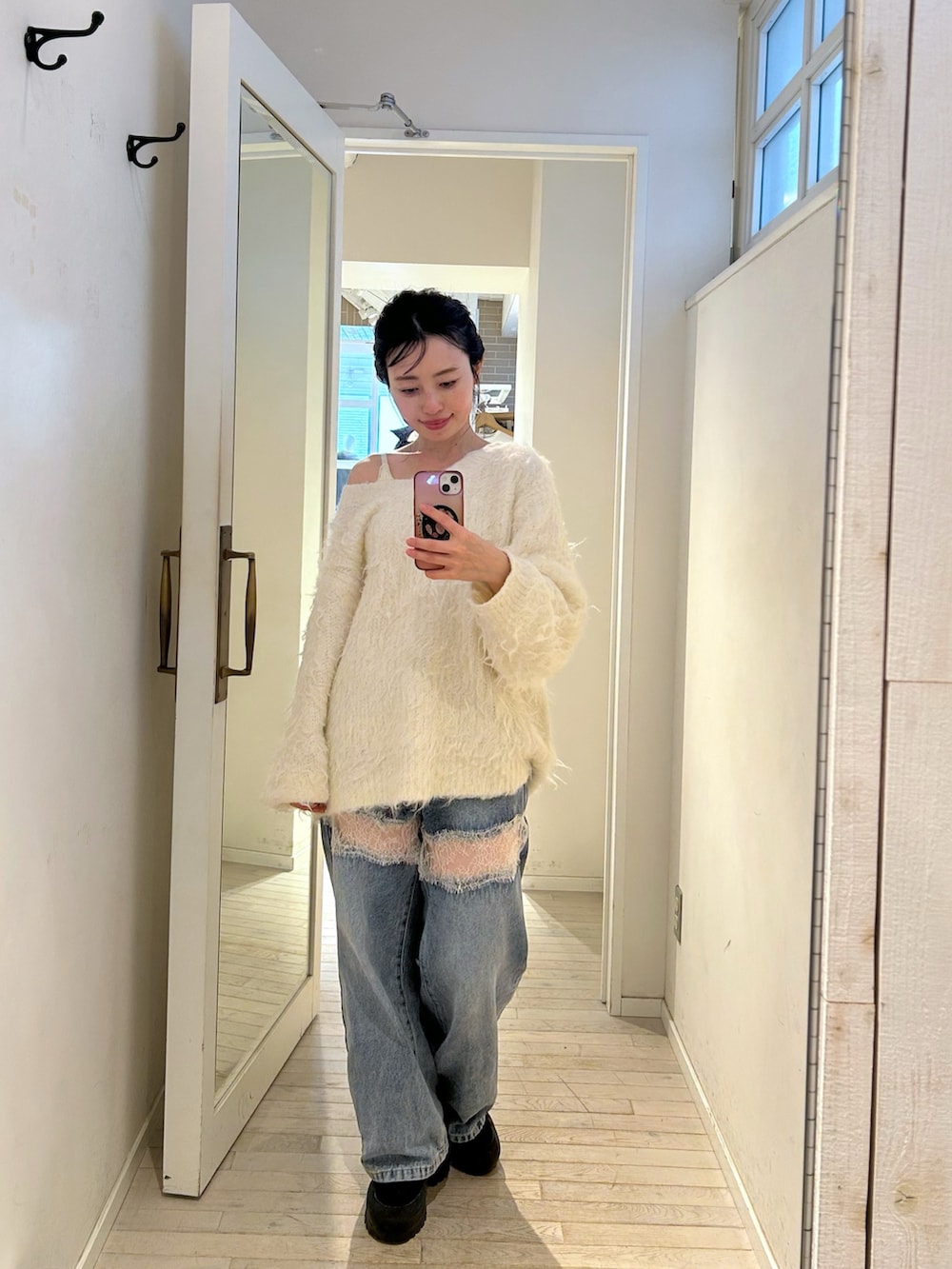 ホワイト系のニット/セーター、ブルー系のデニムパンツを着用したレディースの秋コーディネートの2枚目の写真