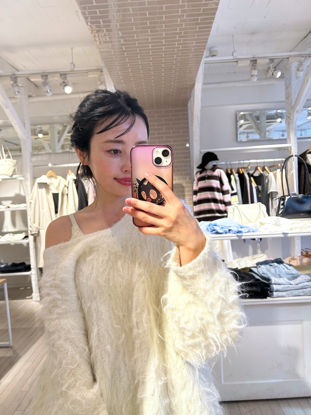 ホワイト系のニット/セーター、ブルー系のデニムパンツを着用したレディースの秋コーディネートの3枚目の写真