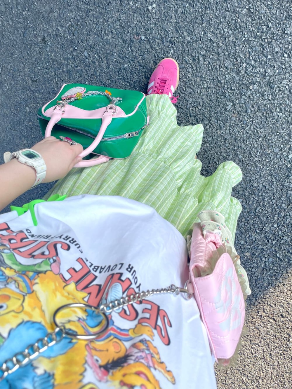 グリーン系のスカート、ピンク系のショルダーバッグ、ピンク系のボストンバッグを着用したレディースの秋コーディネートの2枚目の写真