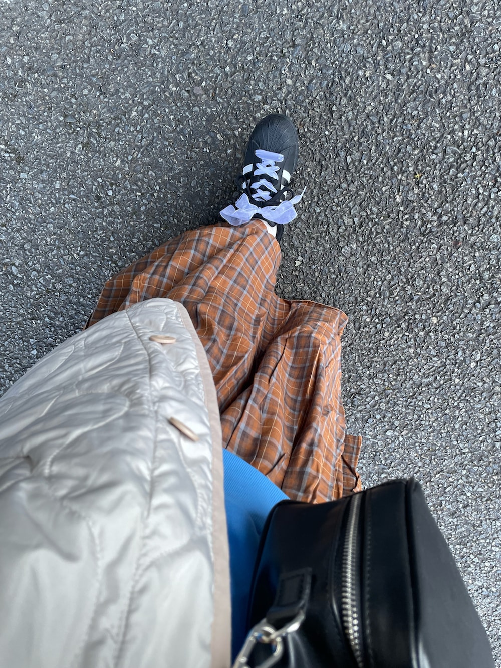 ブラウン系のスカート、ブルー系のスウェット、ブラック系のボストンバッグを着用したレディースの冬コーディネートの3枚目の写真