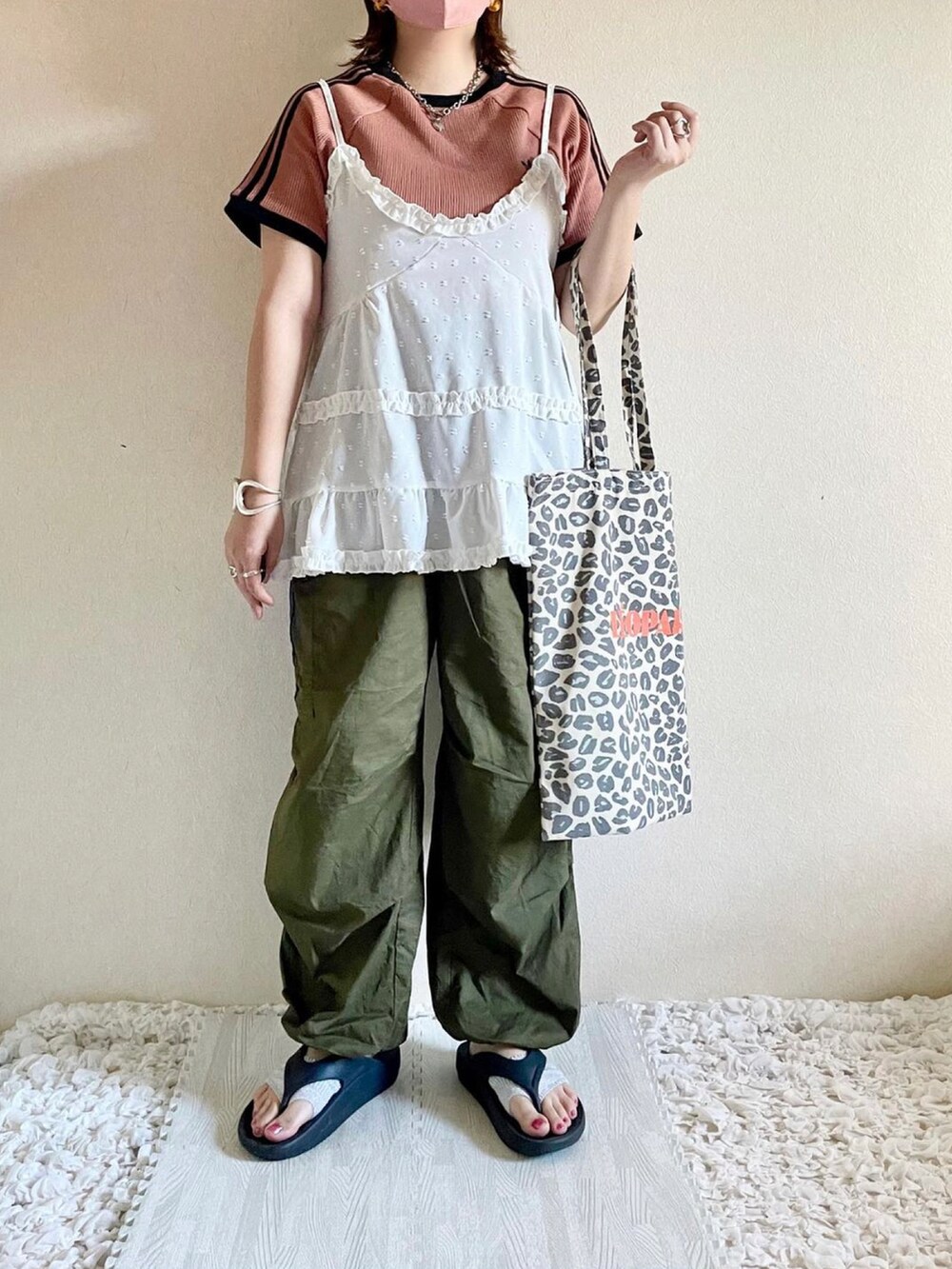 ホワイト系のキャミソール、ブラウン系のTシャツ/カットソー、ブラック系のパンツを着用したレディースの秋コーディネートの2枚目の写真