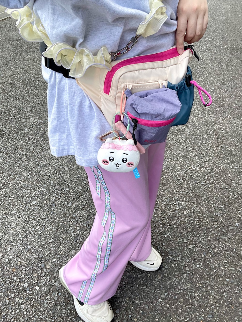 ホワイト系のスニーカー、ホワイト系のTシャツ/カットソー、ホワイト系のボディバッグ/ウエストポーチを着用したレディースの秋コーディネートの2枚目の写真