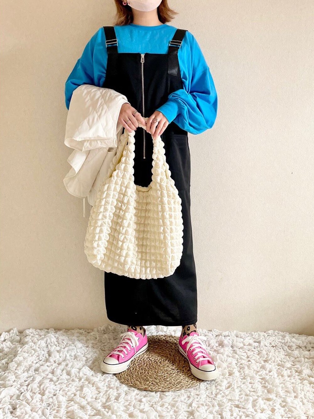 ブルー系のTシャツ/カットソー、グリーン系のベスト、ブラック系のジャンパースカートを着用したレディースの秋コーディネートの2枚目の写真