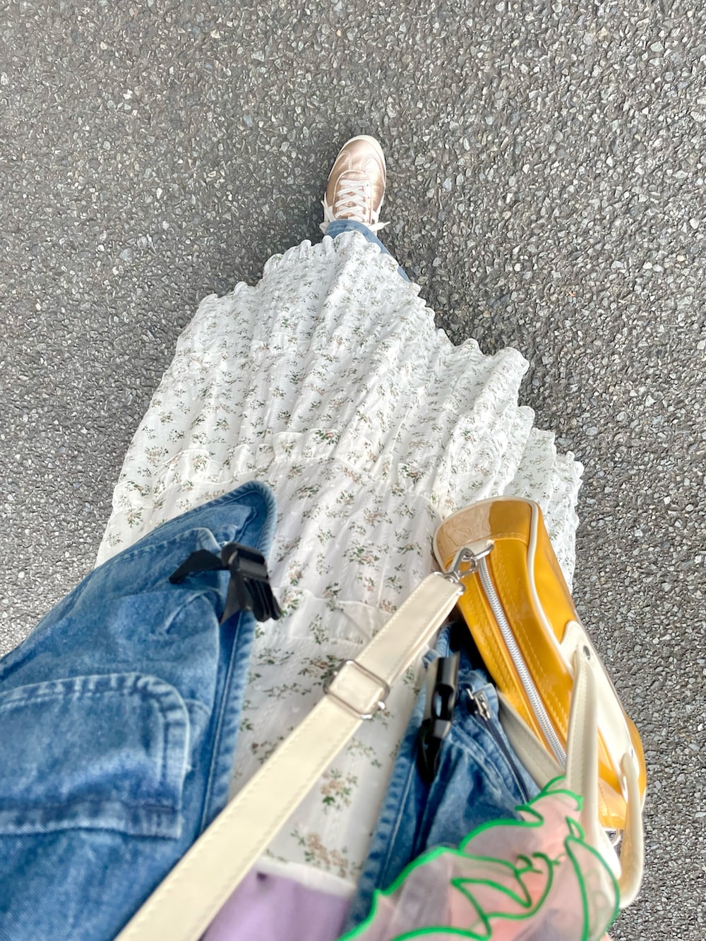 イエロー系のショルダーバッグ、ゴールド系のスニーカー、ホワイト系のワンピースを着用したレディースの秋コーディネートの2枚目の写真