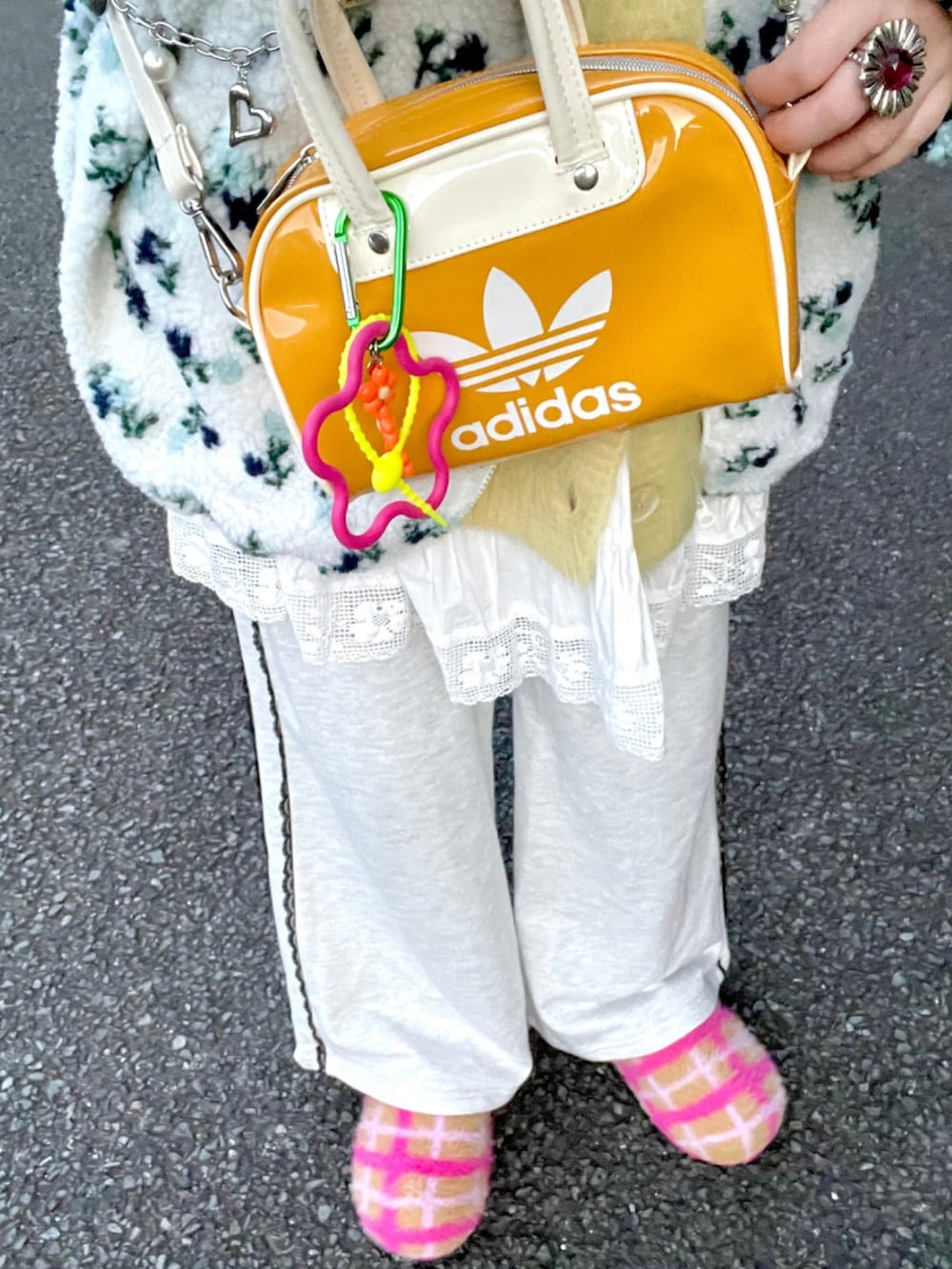 イエロー系のカーディガン/ボレロ、イエロー系のショルダーバッグ、ホワイト系のスカートを着用したレディースの冬コーディネートの3枚目の写真