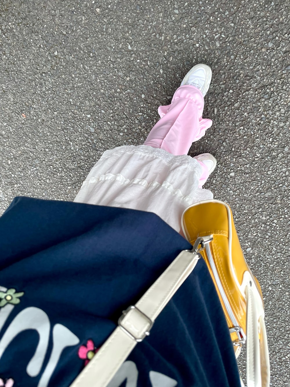 イエロー系のショルダーバッグ、ブルー系のTシャツ/カットソー、ホワイト系のスニーカーを着用したレディースの夏コーディネートの2枚目の写真