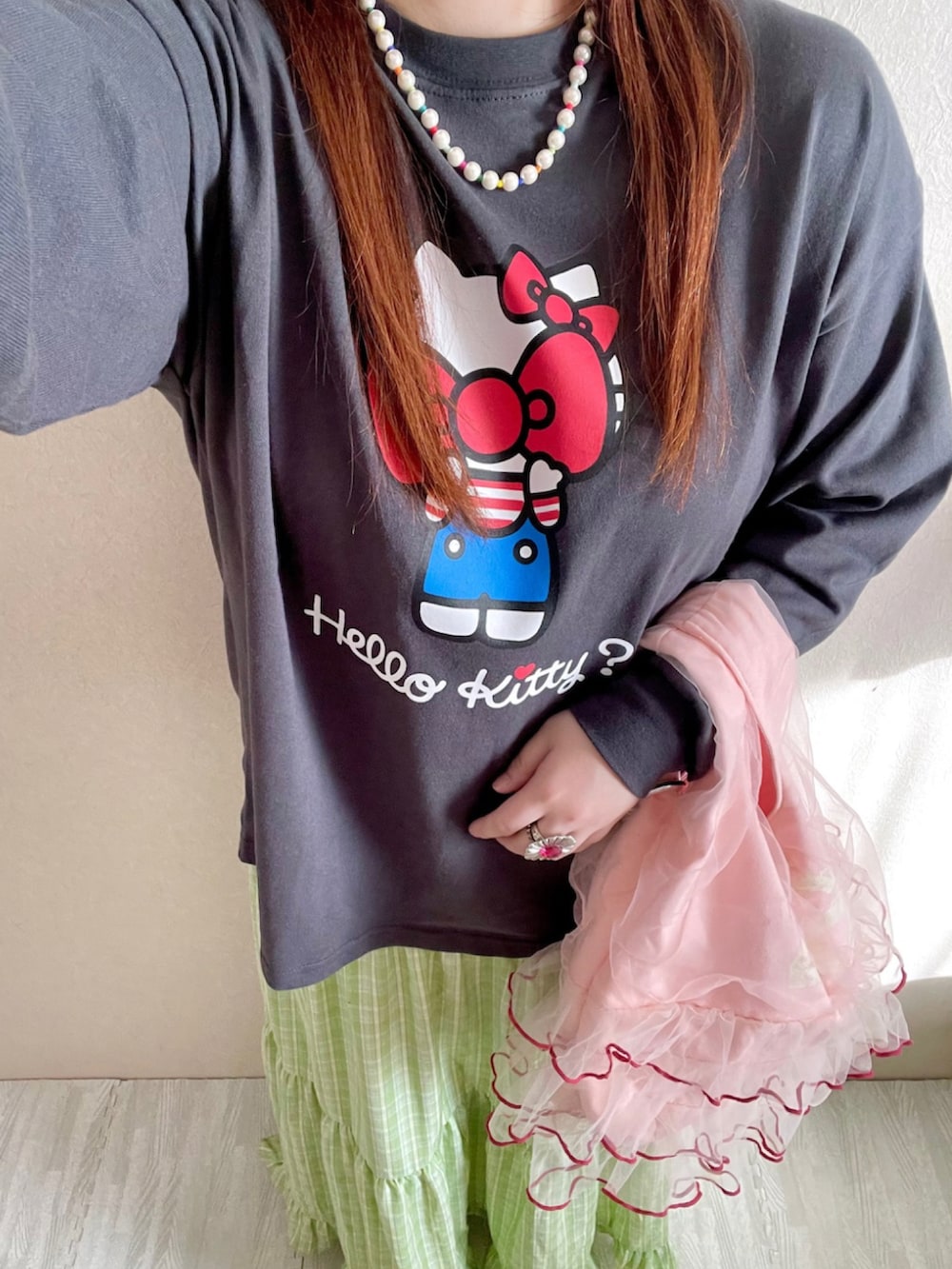 グリーン系のスカート、ブラック系のTシャツ/カットソー、ピンク系のショルダーバッグを着用したレディースの冬コーディネートの2枚目の写真