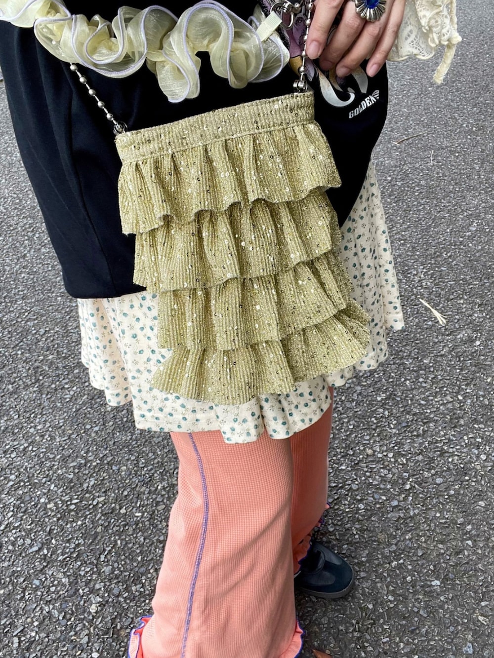 ホワイト系のTシャツ/カットソー、ゴールド系のショルダーバッグ、ブラック系のスニーカーを着用したレディースの春コーディネートの3枚目の写真