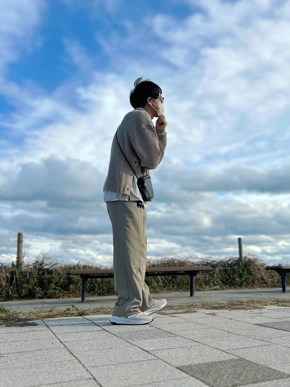 ブラウン系のステンカラーコート、ベージュ系のニット/セーター、グレー系のシャツ/ブラウスを着用したメンズの冬コーディネートの2枚目の写真