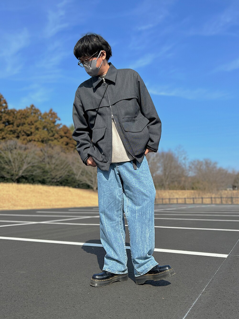 グレー系のブルゾン、グレー系のニット/セーター、ブラック系のショルダーバッグを着用したメンズの春コーディネートの2枚目の写真