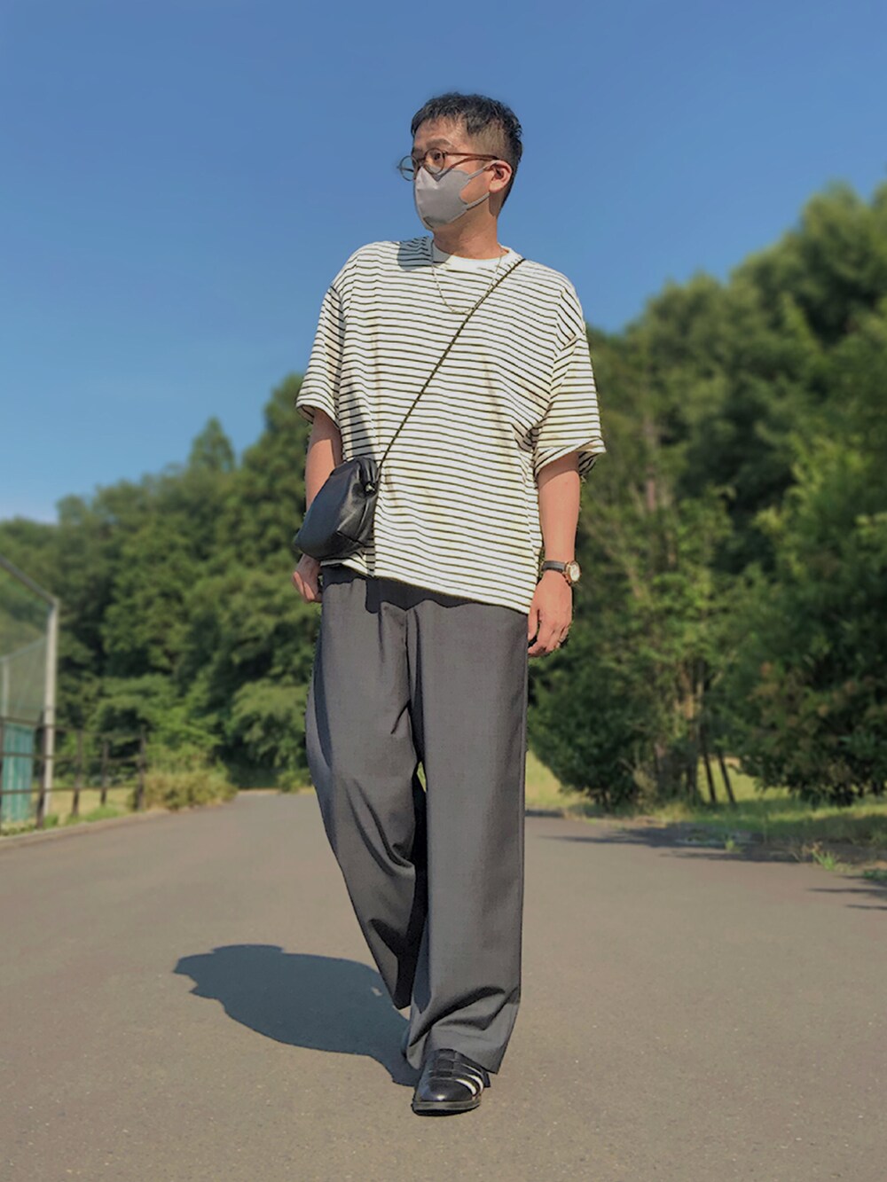 ベージュ系のセットアップ、ホワイト系のTシャツ/カットソー、ブラック系のショルダーバッグを着用したメンズの夏コーディネートの2枚目の写真