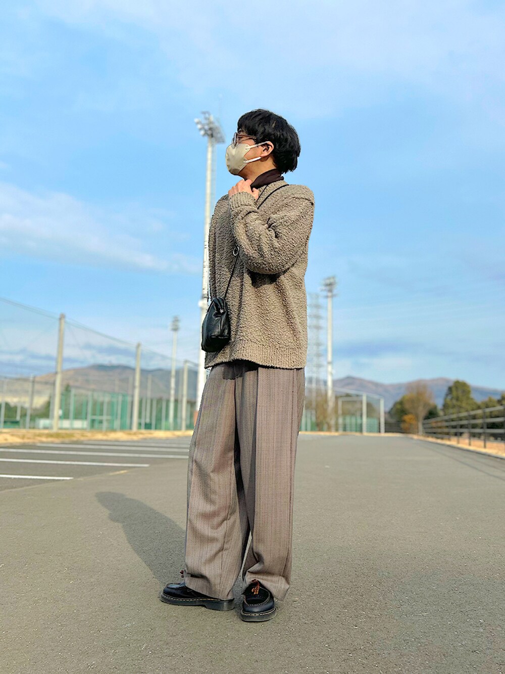 ブラウン系のTシャツ/カットソー、ブラウン系のニット/セーター、グレー系のブルゾンを着用したメンズの冬コーディネートの2枚目の写真