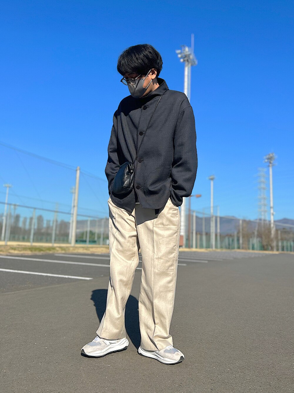 グレー系のブルゾン、グレー系のスウェット、ブラック系のショルダーバッグを着用したメンズの春コーディネートの2枚目の写真