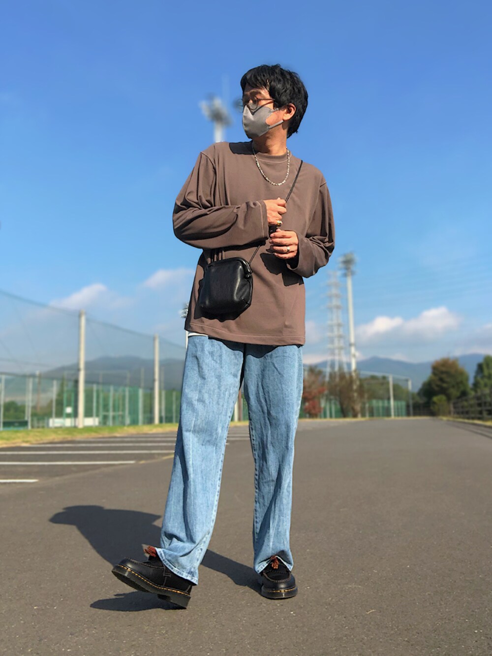 ブラウン系のTシャツ/カットソー、ブラック系のショルダーバッグ、グレー系のタンクトップを着用したメンズの秋コーディネートの2枚目の写真