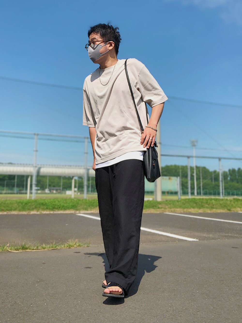 ベージュ系のセットアップ、ブラック系のショルダーバッグ、グレー系のTシャツ/カットソーを着用したメンズの夏コーディネートの2枚目の写真
