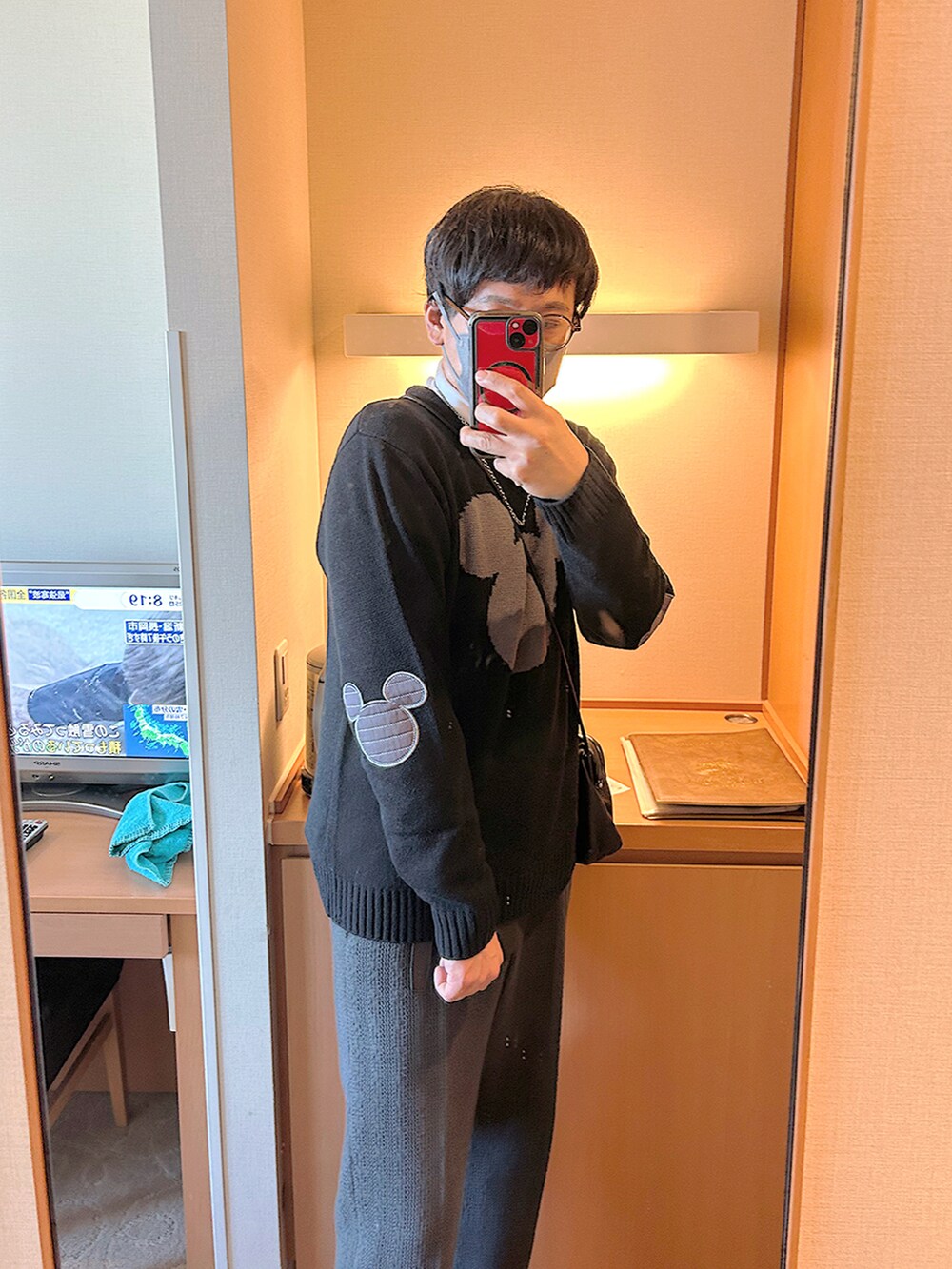 ホワイト系のTシャツ/カットソー、ブラック系のニット/セーター、グレー系のダウンジャケット/コートを着用したメンズの冬コーディネートの5枚目の写真
